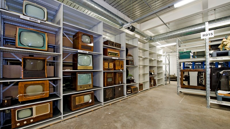 A collection of vintage TVs on shelves in one of the storage rooms at GMRC