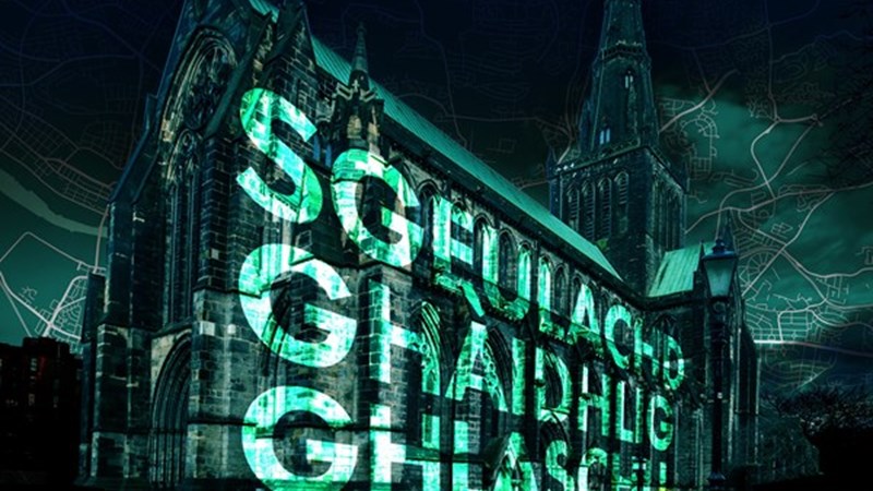 Gaelic text projected onto a building facade