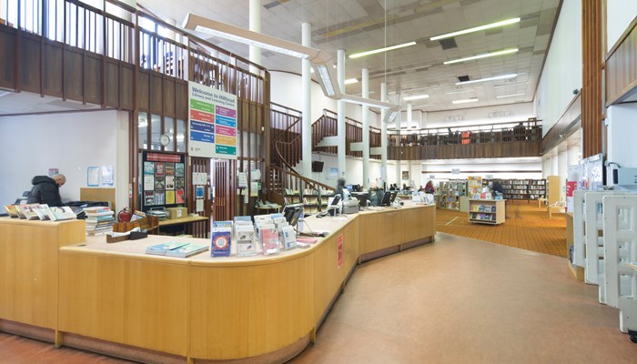 A long curved wooden desk at the entrance to Hillhead Library.