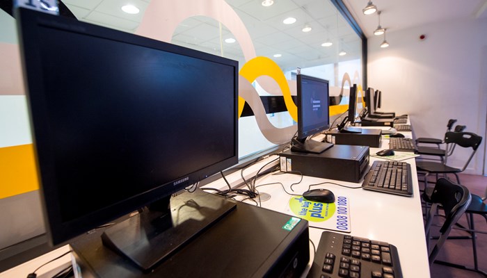 A row of black PC's on a white table